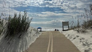 A beach pathway leading to the ocean with a blue umbrella and a signboard. - Updated villa minutes walk to the beach. Seasonal heated outdoor pool (Hilton Head Island)