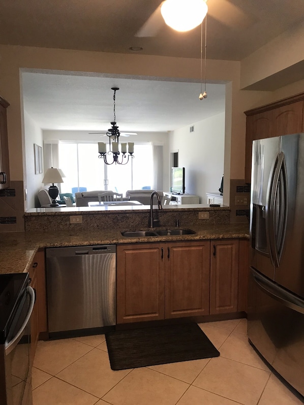 Enjoy cooking in this well-equipped kitchen with a central island, stainless steel appliances, and a large window.