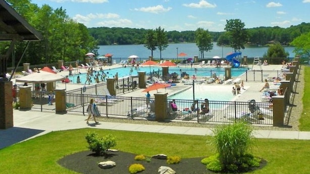 A pool area with multiple pools, umbrellas, and lounge chairs.