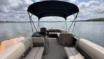 Bootinterieur met een overdekte zithoek, een stuurwiel en een klein tafeltje.