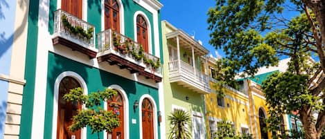 A row of colorful buildings with balconies and potted plants.