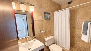 A bathroom with a sink, toilet, and shower curtain. - Beachfront in * Isla Verde * walk 2 eat * (Carolina)