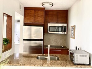 Fridge, microwave, coffee/tea maker, cookware/dishes/utensils