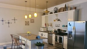 A modern kitchen with a central island, stainless steel appliances, and decorative wall art.
