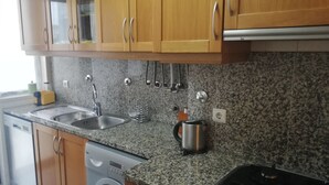 Eine Küche mit Granit-Arbeitsplatten, Edelstahlgeräten und Holzausstattung.