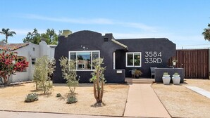 Una casa moderna con fachada negra, un ventanal visible y el número '3584 33RD' en el lateral.