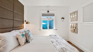 Un dormitorio con cama, ventana y decoración en la pared.