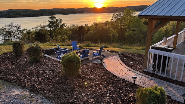 A lakeside patio with Adirondack chairs, a stone pathway, and a wooden deck with a railing. - Douglas Lake, TN Lake View Retreat with lake access (Newport)