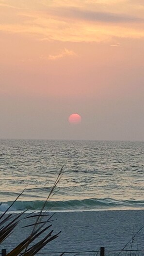 A sunset over the ocean with waves.