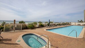 A rooftop pool with a view of the ocean, surrounded by lounge chairs and a fence. - OPEN 10/3-10/5 OR 10/19-10/26 2 FREE Beach chairs  Condo on the Beach (Panama City Beach)