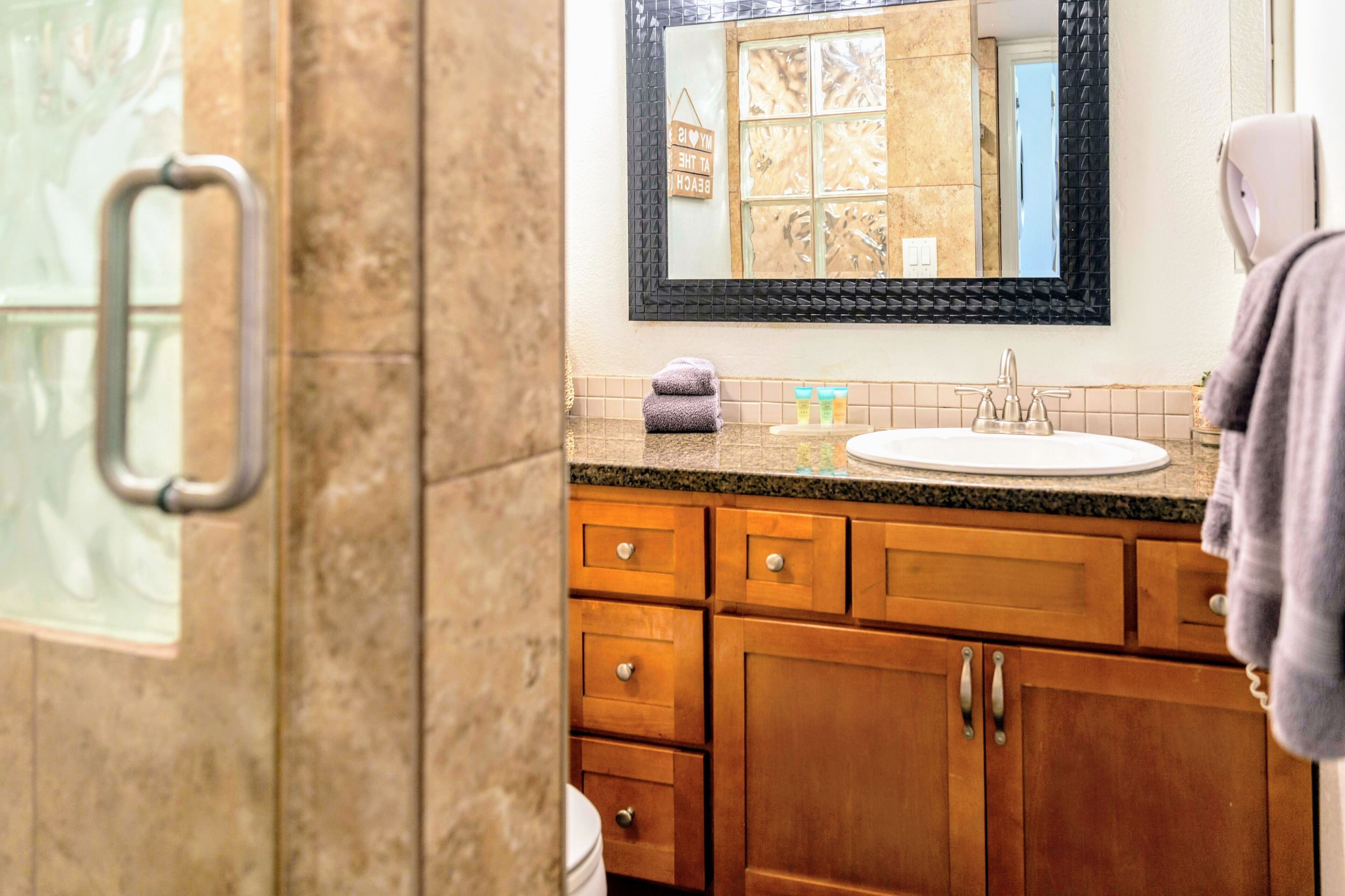 A bathroom with a sink, mirror, and wooden cabinets.