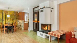 Ein Wohnzimmer mit Kamin, Essbereich und Küche.
