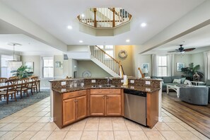 A spacious kitchen with a central island, wooden cabinets, and a stainless steel dishwasher.