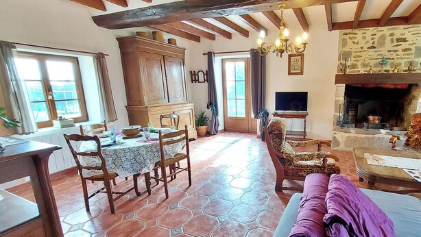 Un comedor con una mesa preparada para cuatro personas, un sofá y una chimenea.