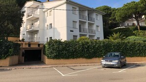 A multi-story residential building with balconies, a parking area, and a driveway leading to a garage. - El Balconet de Calella de Palafrugell (Calella de Palafrugell)