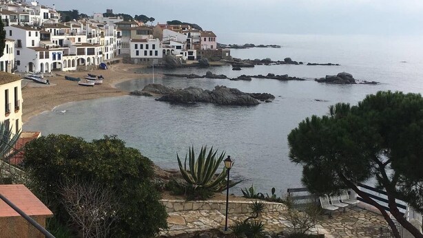 A coastal town with white buildings, a beach, and rocky outcrops in the water. - El Balconet de Calella de Palafrugell (Calella de Palafrugell)