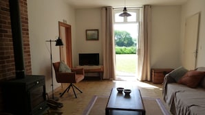 Una sala de estar acogedora con chimenea, televisión, sofá y mesa de comedor.