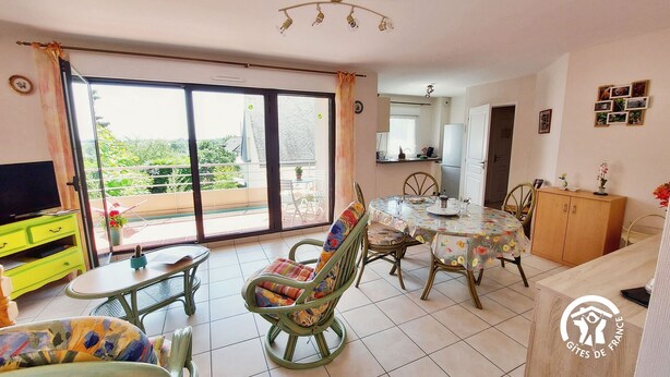 A dining area with a table, chairs, and a television. - Bright 2-Bedroom Apartment with Balcony, Garage & Baby Equipment near Mayenne's Attractions (Mayenne)