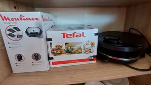 A shelf with a white box labeled 'Moulinex' and a white box labeled 'Tefal'. - Bright 2-Bedroom Apartment with Balcony, Garage & Baby Equipment near Mayenne's Attractions (Mayenne)