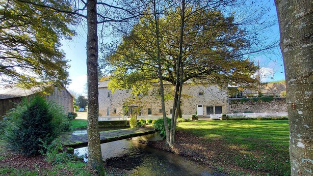 A stone building with a small stream running through a garden. - Riverside Retreat: Spacious 3BR House, Private Fishing Pond, Near Charming Villages & Outdoor Activities (Voutré)