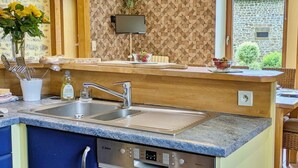 A modern kitchen with a Bosch dishwasher, double sink, and a wooden countertop.