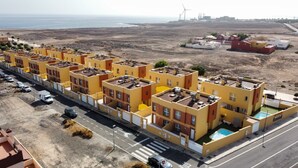 A row of yellow buildings with a swimming pool on the right. - BUTTERFLIES POOL 4 TRANQUILITY AND RELAXATION (Puerto del Rosario)