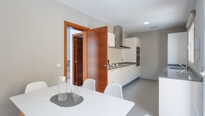 A modern kitchen with white cabinetry, a built-in oven, and a stainless steel sink. - BUTTERFLIES POOL 4 TRANQUILITY AND RELAXATION (Puerto del Rosario)