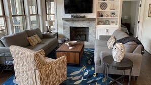 A living room with a fireplace, a television, and a bookshelf.