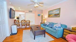 A living room with a blue sofa, wooden coffee table, and a ceiling fan.