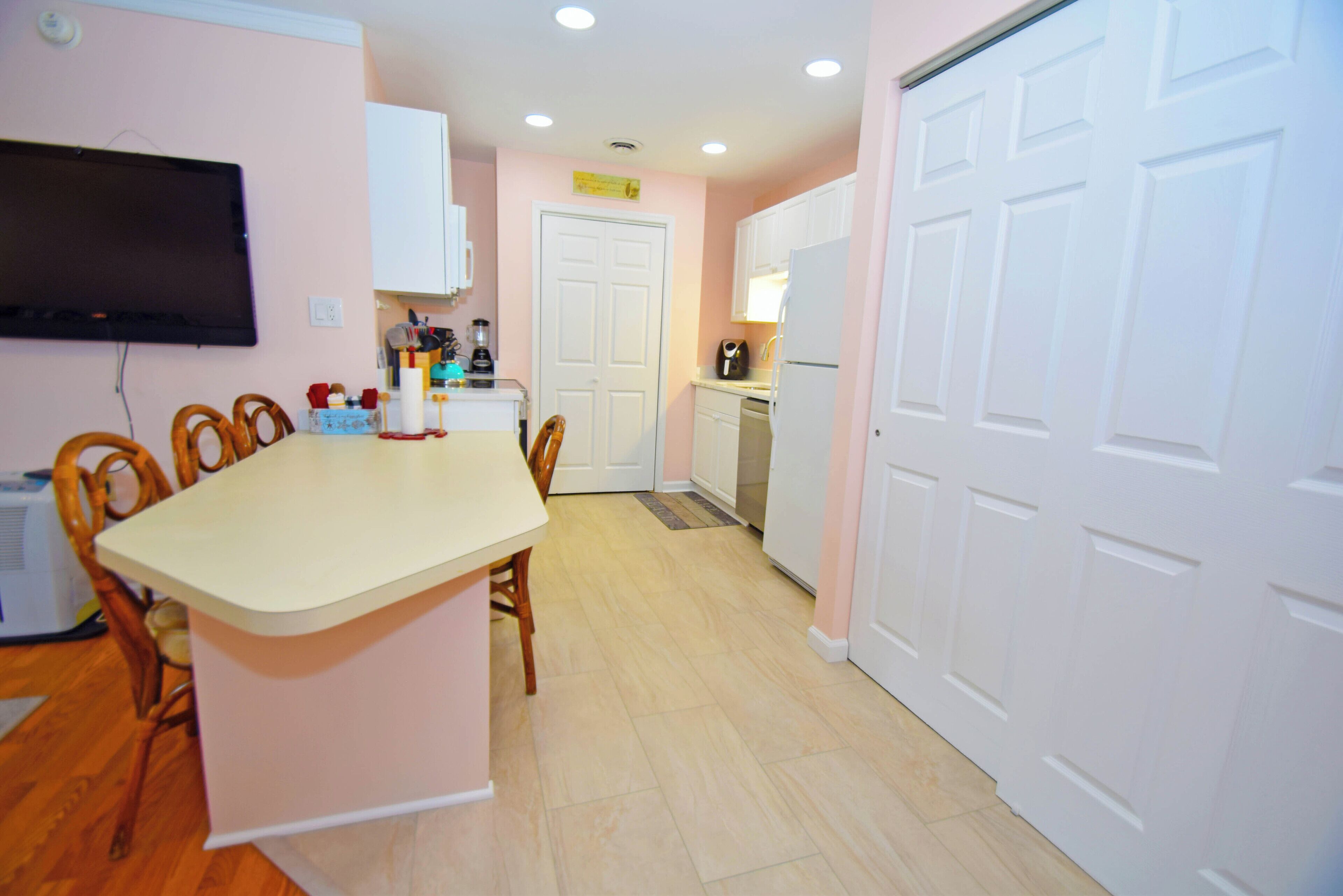 A kitchen with a central island, white cabinets, a refrigerator, and a microwave.