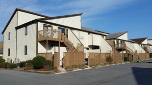 A two-story building with a balcony, a staircase, and a gated entrance.