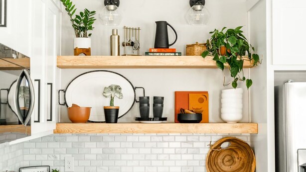 A kitchen with white brick backsplash, wooden shelves, and various kitchen items. - Brand New and One Block from Magnolia Silos! (Waco)
