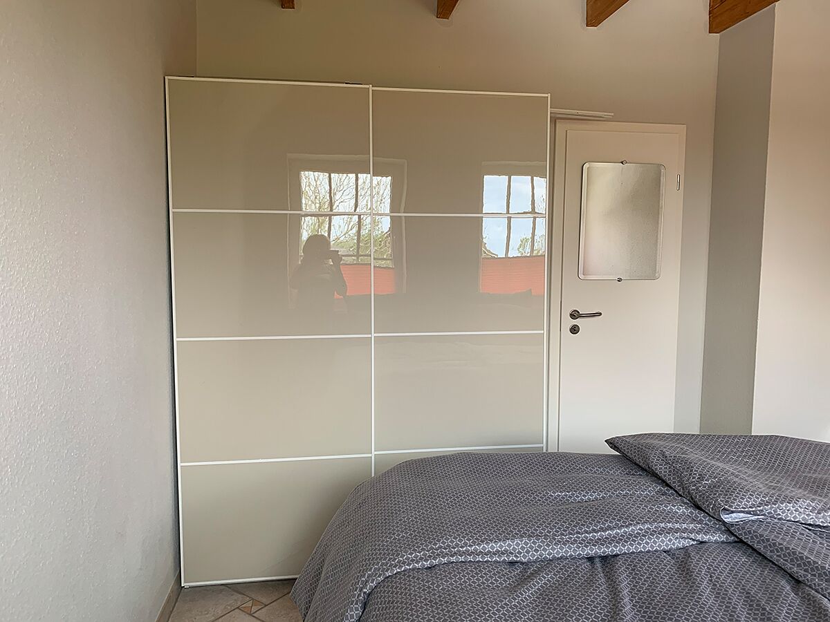 Une chambre à coucher avec un lit, une armoire et une porte.