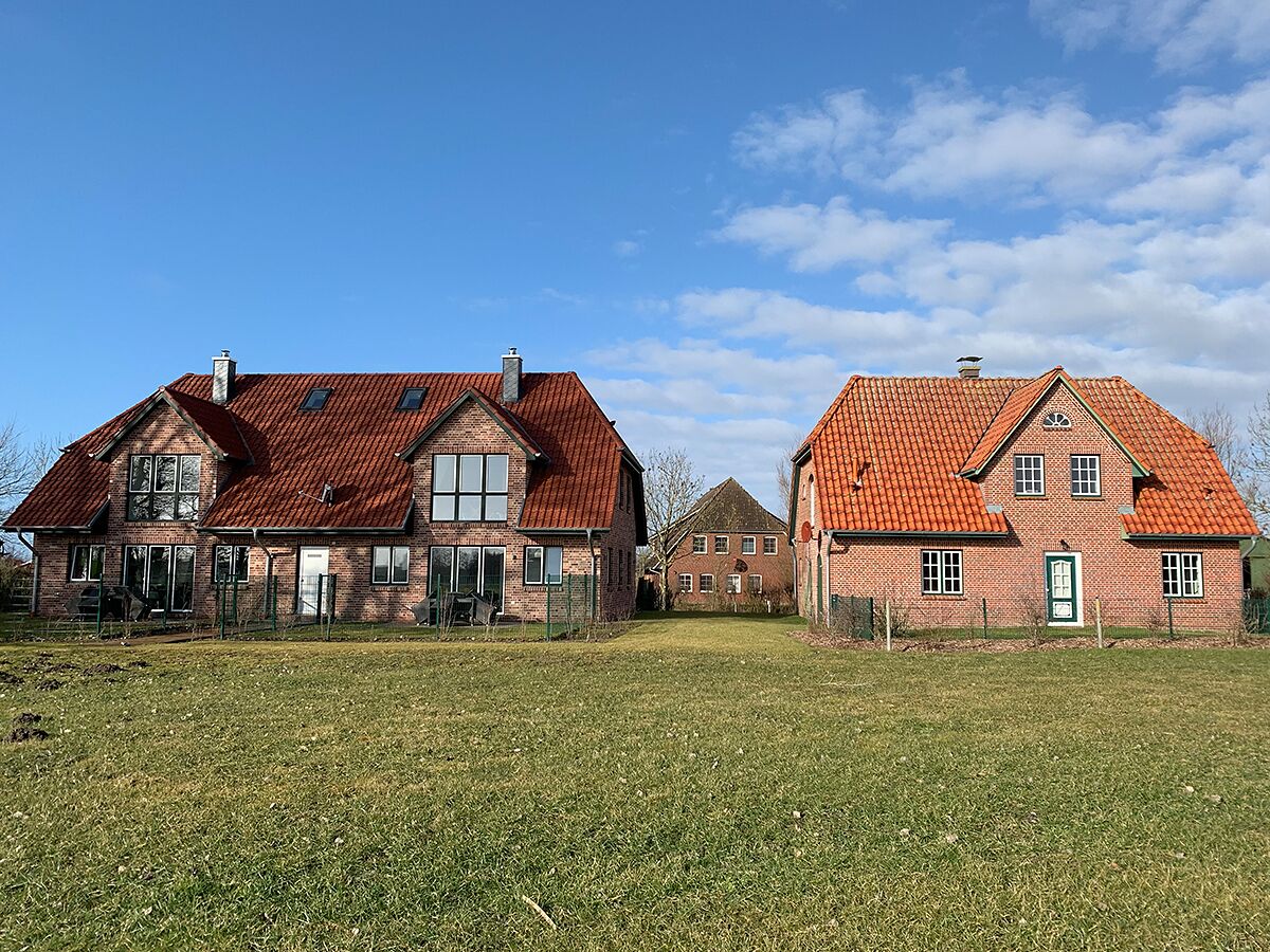 Ein großes Backsteinhaus mit rotem Ziegeldach und ein kleineres, angrenzendes Gebäude.