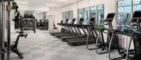 A gym with treadmills, stationary bikes, and weight machines.