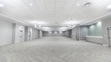 A spacious, well-lit hotel lobby with a tiled ceiling, multiple doors, and a reception desk.
