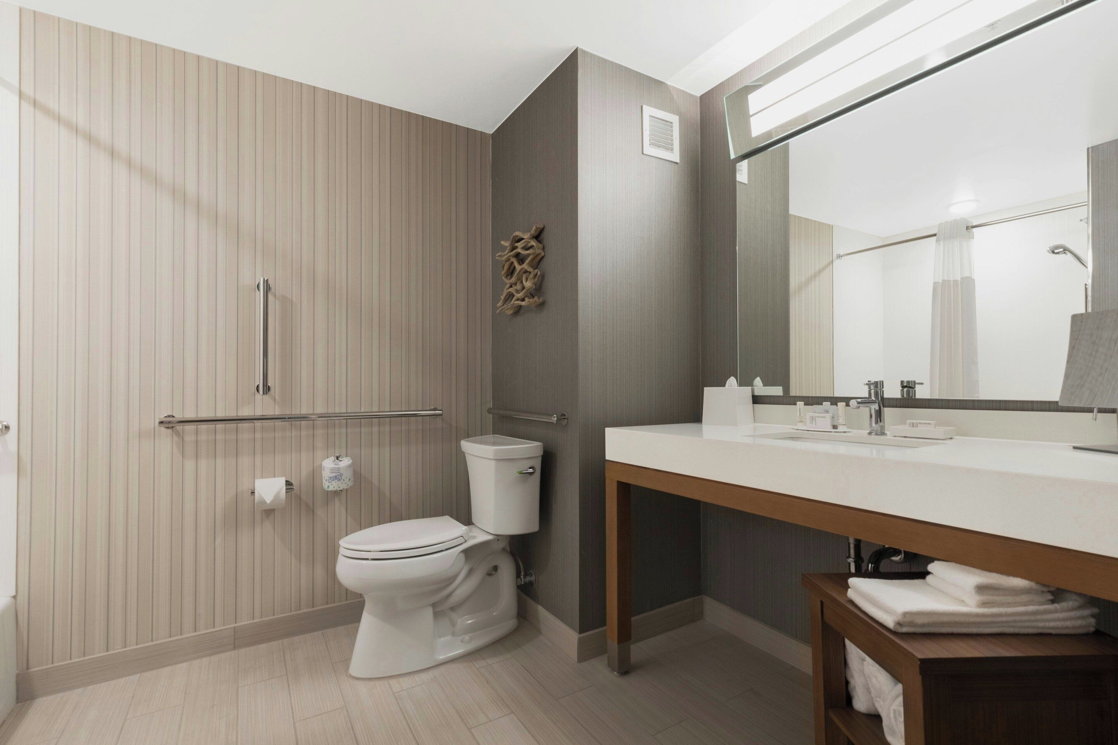 A modern bathroom with a toilet, sink, and shower area.