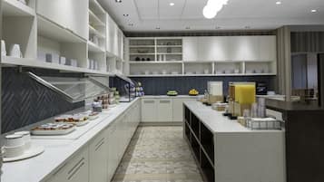 A modern kitchen with white cabinetry, a herringbone-patterned backsplash, and a geometric tile floor.