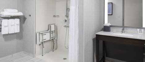 A modern bathroom with a walk-in shower, a vanity with a sink, and a towel rack.