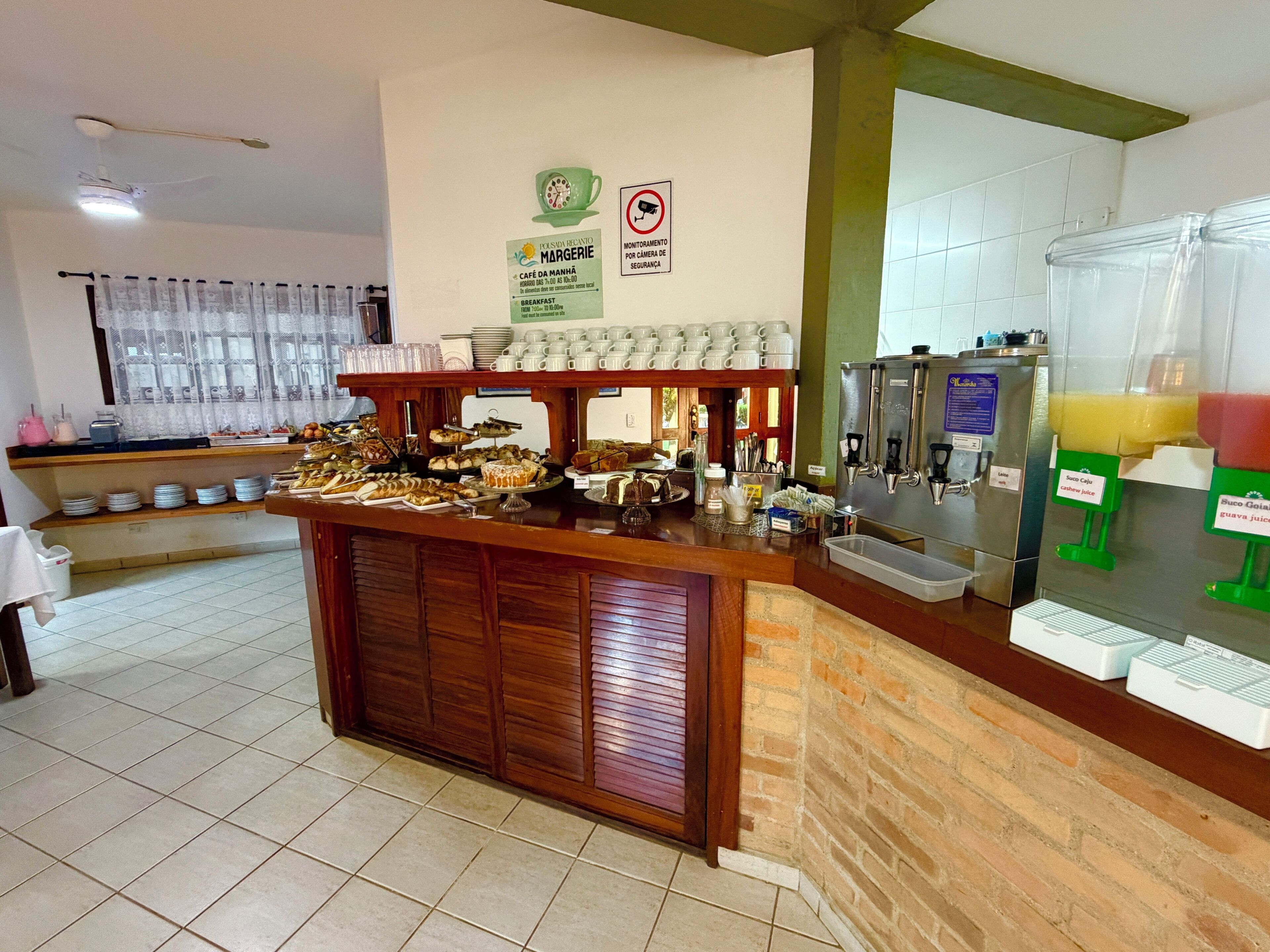 A buffet area with various food items, a coffee station, and a juice dispenser.