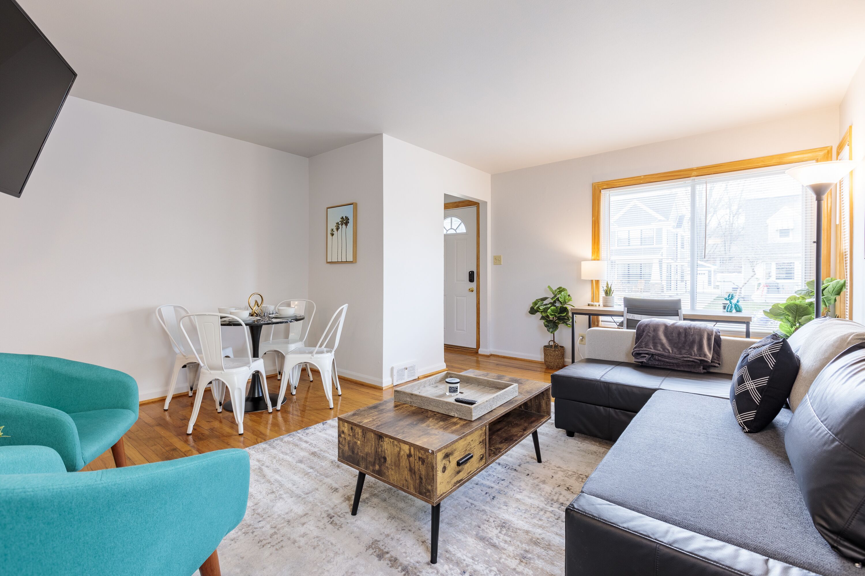 A modern living room with a sofa, a coffee table, and a dining area with chairs.