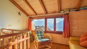 A wooden interior with a rocking chair, a sofa, and a window with curtains. - Cozy home in Telve di Sopra (Telve di Sopra)