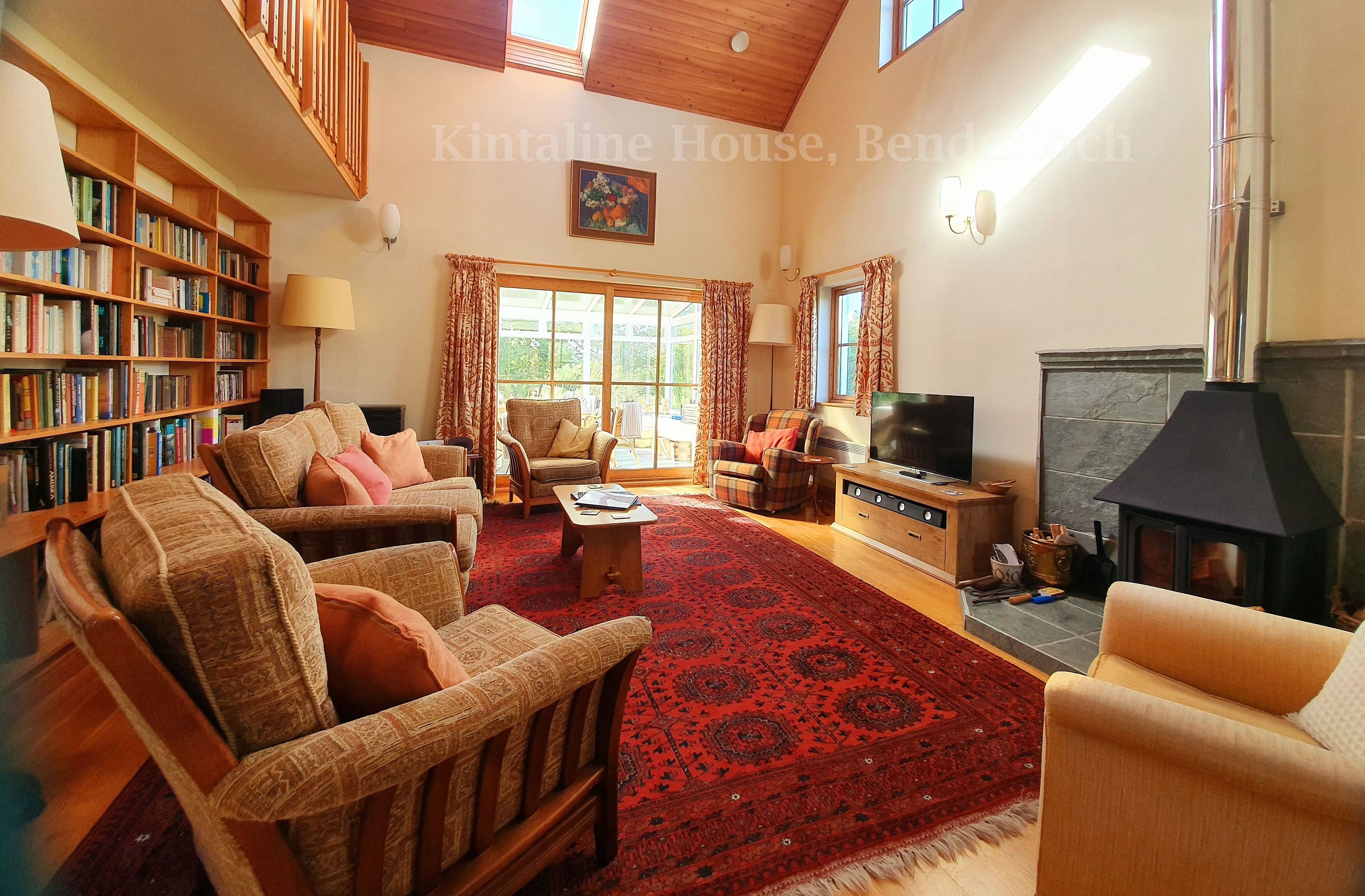 double height large living space, woodstove, free firewood, library, comfortable
