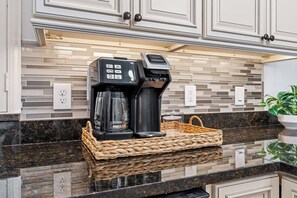 A kitchen with a coffee maker, a basket, and a potted plant. - Citrus Hideaway l Hot Tub l 1 Block to Downtown (St. Augustine)