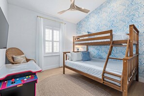 A room with a bunk bed, a desk with a toy, a chair, and a window with curtains. - Citrus Hideaway l Hot Tub l 1 Block to Downtown (St. Augustine)