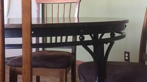 Un comedor con una mesa y sillas de madera, un cuadro en la pared y una llave decorativa colgada a su lado.