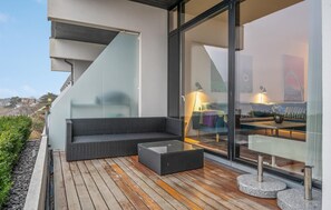 Relax in this stylish outdoor space with a sofa, coffee table, and minimalist lamp.