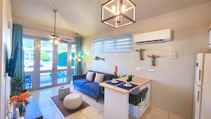 A compact living space with a sofa, dining table, kitchenette, and a ceiling fan. - Casa Tortuga | Beachfront Villa | Pool | Aguada PR (Aguada)