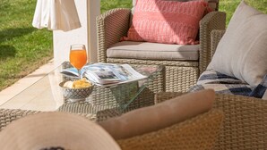 A wicker sofa with cushions, a glass table with a bowl of chips and a drink, and a magazine. - Gorgeous home in Barban (Barban)