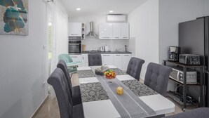 A modern kitchen with white cabinets, a built-in oven, and a coffee machine. - Gorgeous home in Barban (Barban)